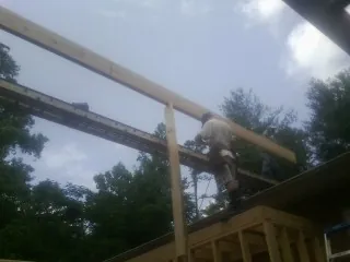 Carpenter setting a ridge beam over a new addition frame — Ice Dam Removal by Roofing Brothers in Boiling Springs